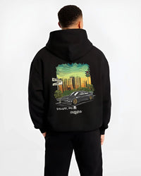Black hoodie worn by a male model, back view, featuring Dodge Charger skyline american muscle street classic racing graphic.