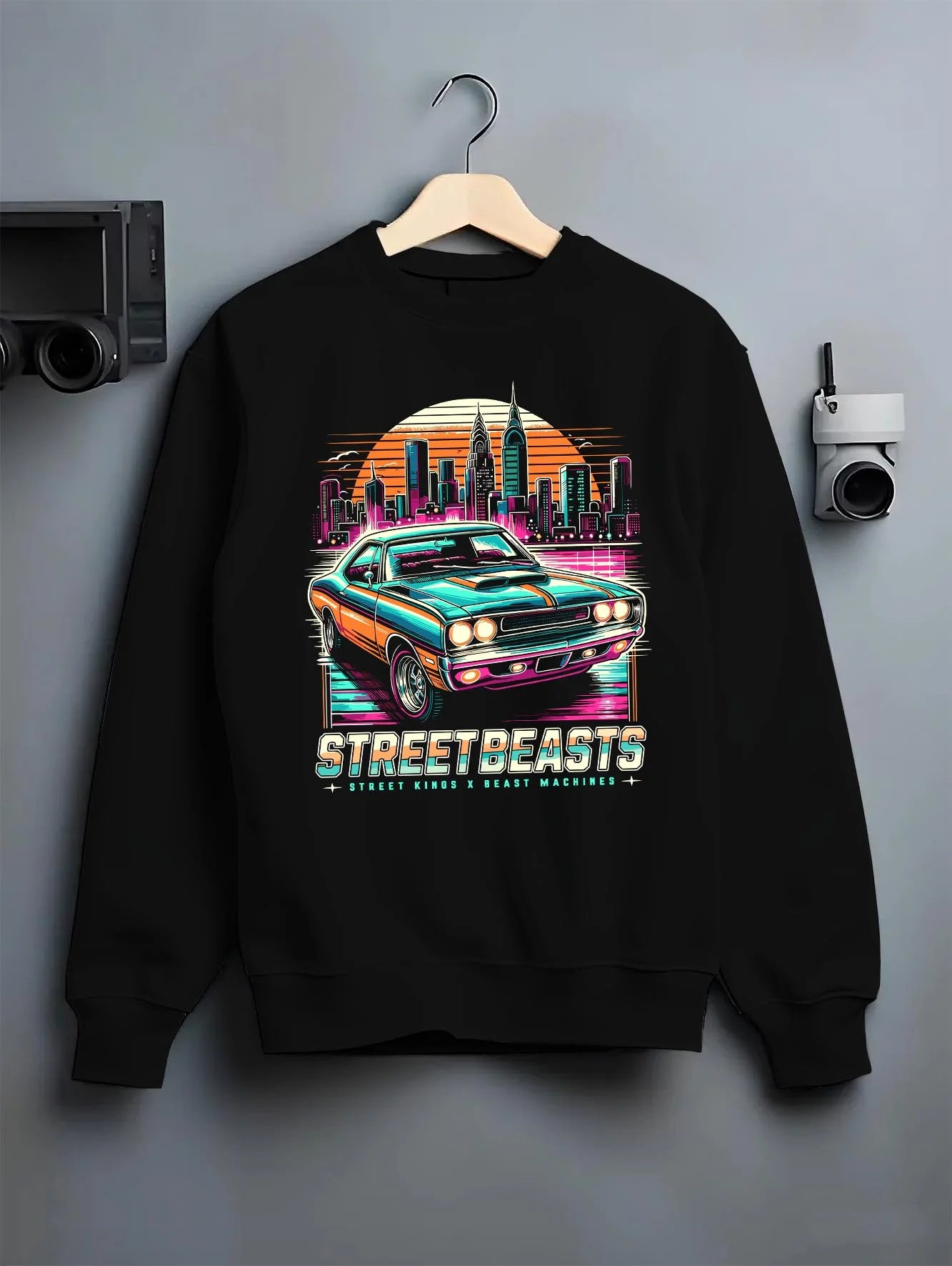 Black crewneck sweatshirt on a hanger against a grey wall, featuring racing drift muscle street retro beast performance graphic.