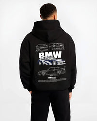 Black hoodie worn by a male model, back view, featuring BMW racing drift german tuner enthusiast street performance graphic.