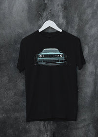 Black crewneck T-shirt on a hanger against a grey wall, featuring BMW M3 rs drift classic racing street performance graphic.