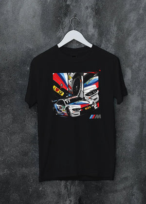 Black crewneck T-shirt on a hanger against a grey wall, featuring BMW M4 rs racing motorsport street performance automotive graphic.