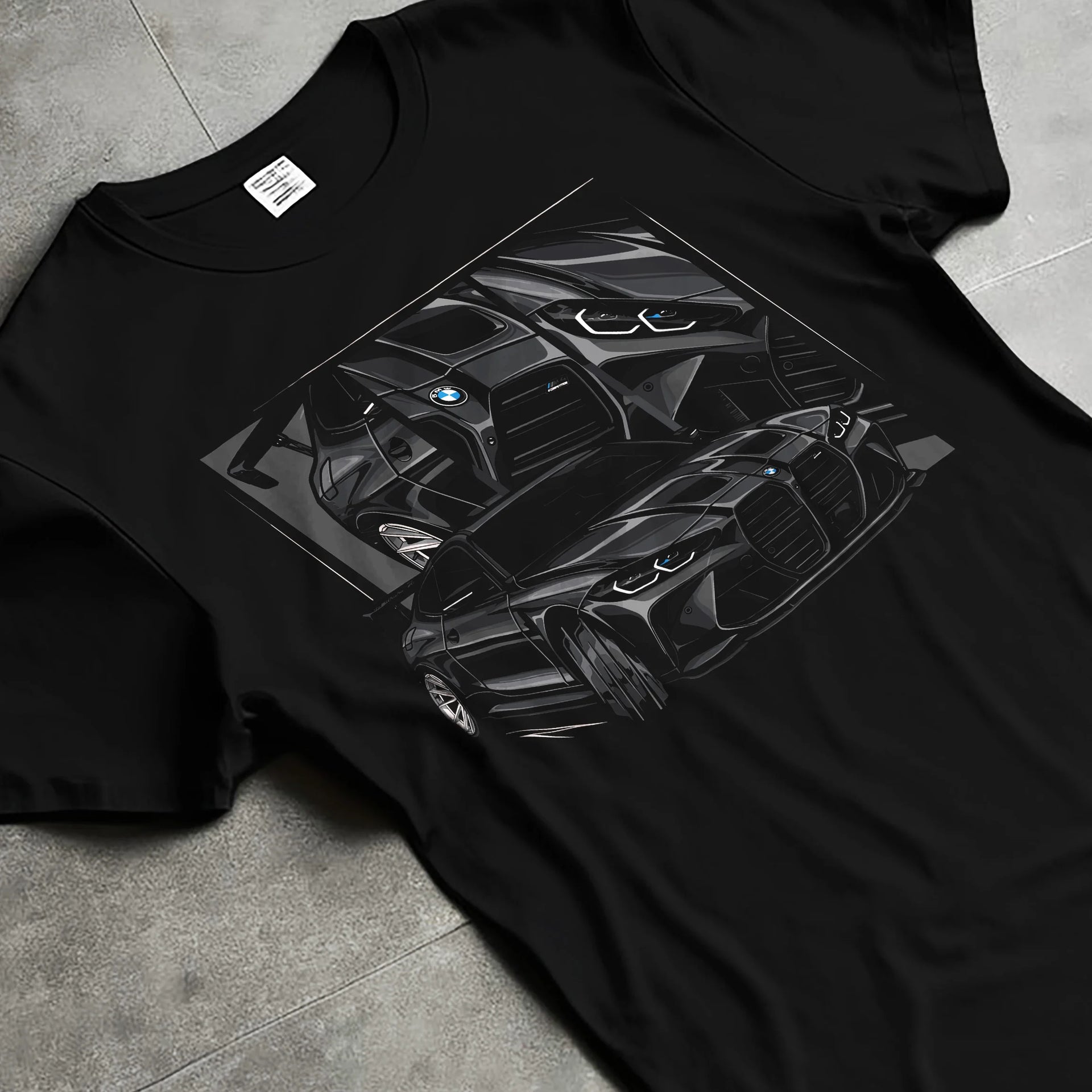 Black T-shirt laid flat with natural fabric folds, featuring BMW M4 german tuner street racing performance motorsport graphic.