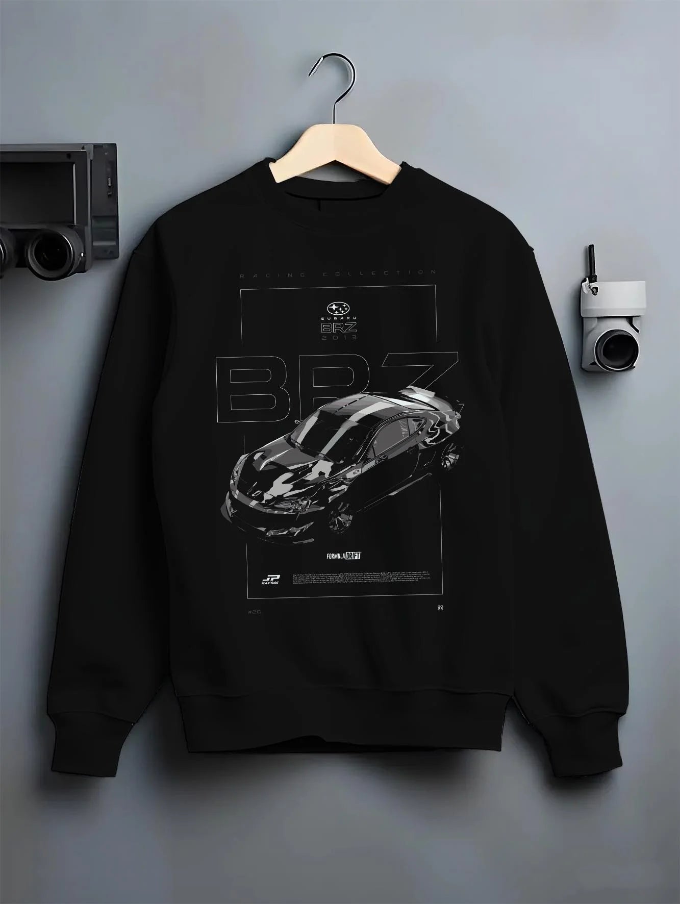 Black crewneck sweatshirt on a hanger against a grey wall, featuring Subaru BRZ rs racing drift formula motorsport jdm graphic.