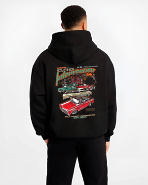 Black hoodie worn by a male model, back view, featuring Chevrolet C10 vintage classic enthusiast meet racing street graphic.