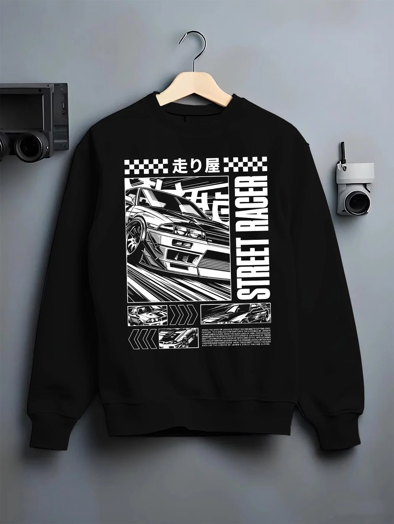 Black crewneck sweatshirt on a hanger against a grey wall, featuring racing street performance motorsport automotive car01.