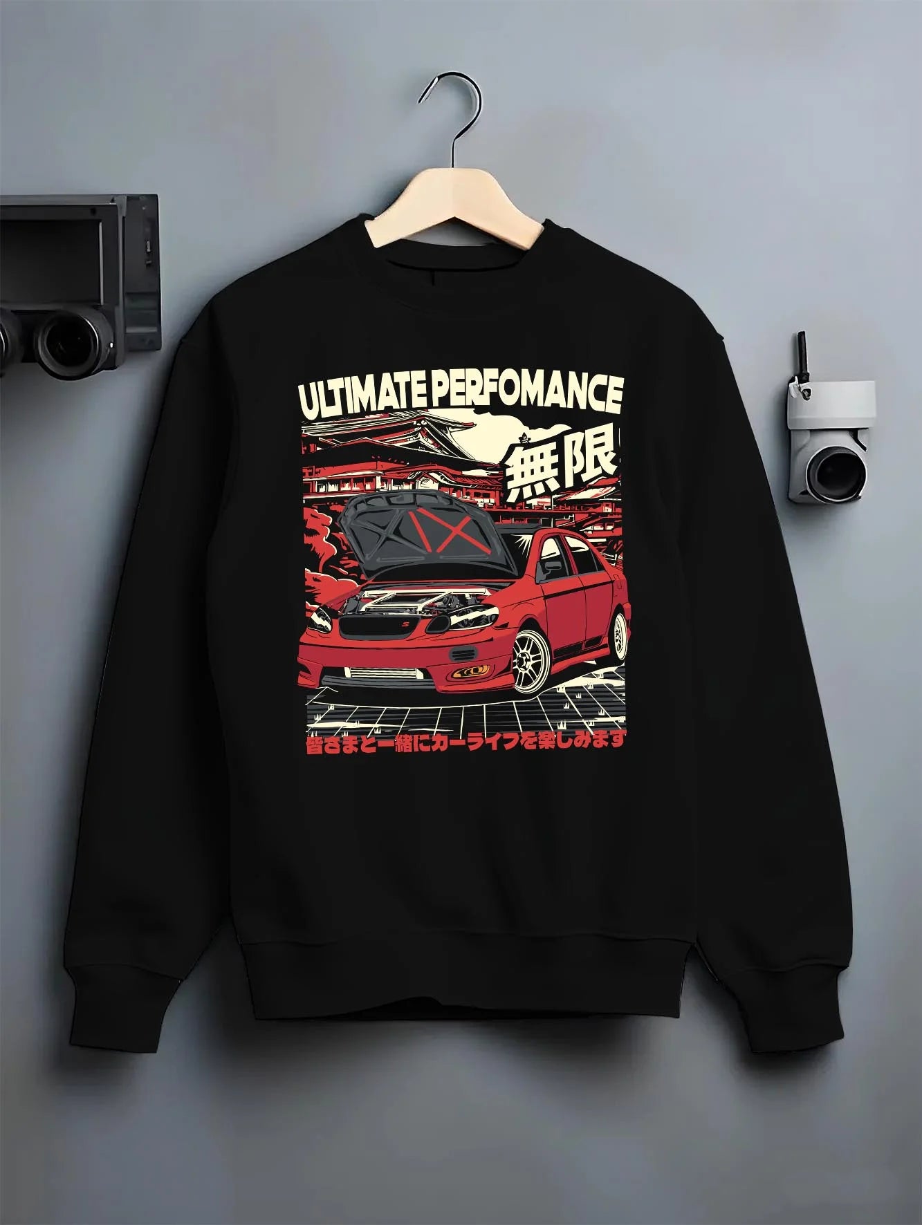 Black crewneck sweatshirt on a hanger against a grey wall, featuring racing street performance motorsport automotive car02.