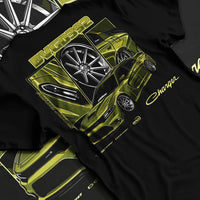 Black T-shirt laid flat with natural fabric folds, featuring Dodge Charger racing jdm american muscle street retro graphic.