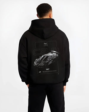 Black hoodie worn by a male model, back view, featuring Chevrolet Corvette C8 corvette racing american muscle street retro graphic.