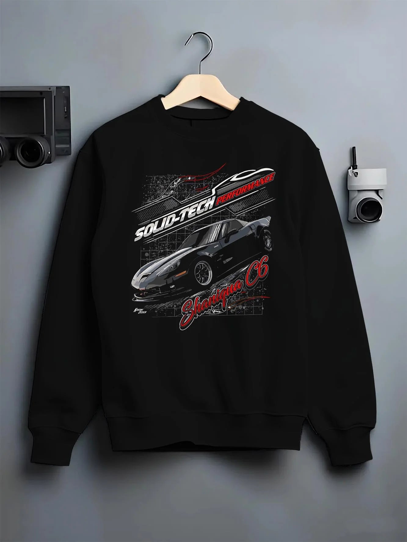 Black crewneck sweatshirt on a hanger against a grey wall, featuring Chevrolet rs racing muscle street retro classic graphic.