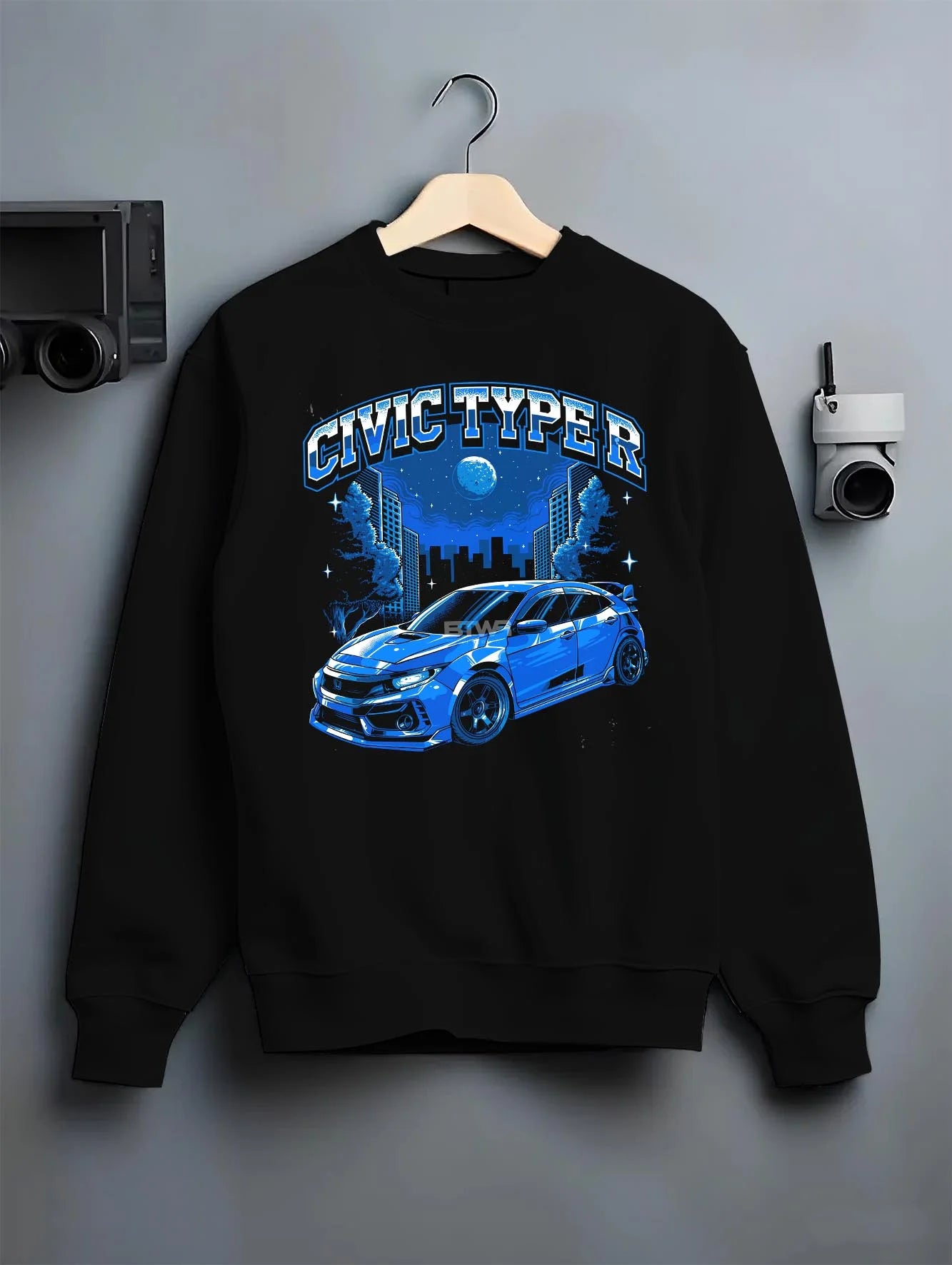 Black crewneck sweatshirt on a hanger against a grey wall, featuring Honda Civic rs racing motorsport jdm street graphic.