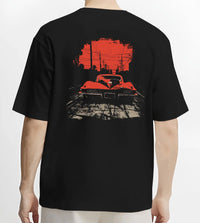 Black T-shirt worn by a male model, back view, featuring Chevrolet Corvette muscle retro classic enthusiast racing street graphic.