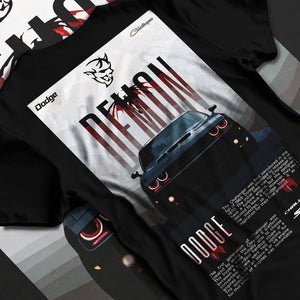 Black T-shirt laid flat with natural fabric folds, featuring Dodge Challenger racing muscle street retro enthusiast graphic.