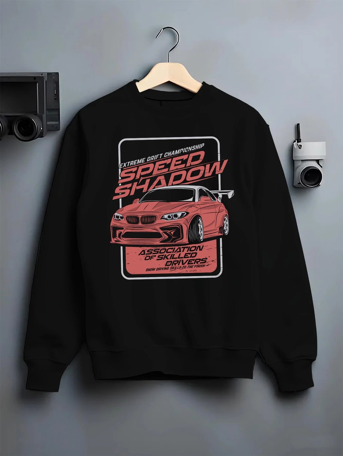 Black crewneck sweatshirt on a hanger against a grey wall, featuring rs racing drift motorsport street speed performance graphic.