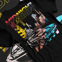 Black T-shirt laid flat with natural fabric folds, featuring racing drift jdm japanese muscle tokyo street midnight tokyo graphic.