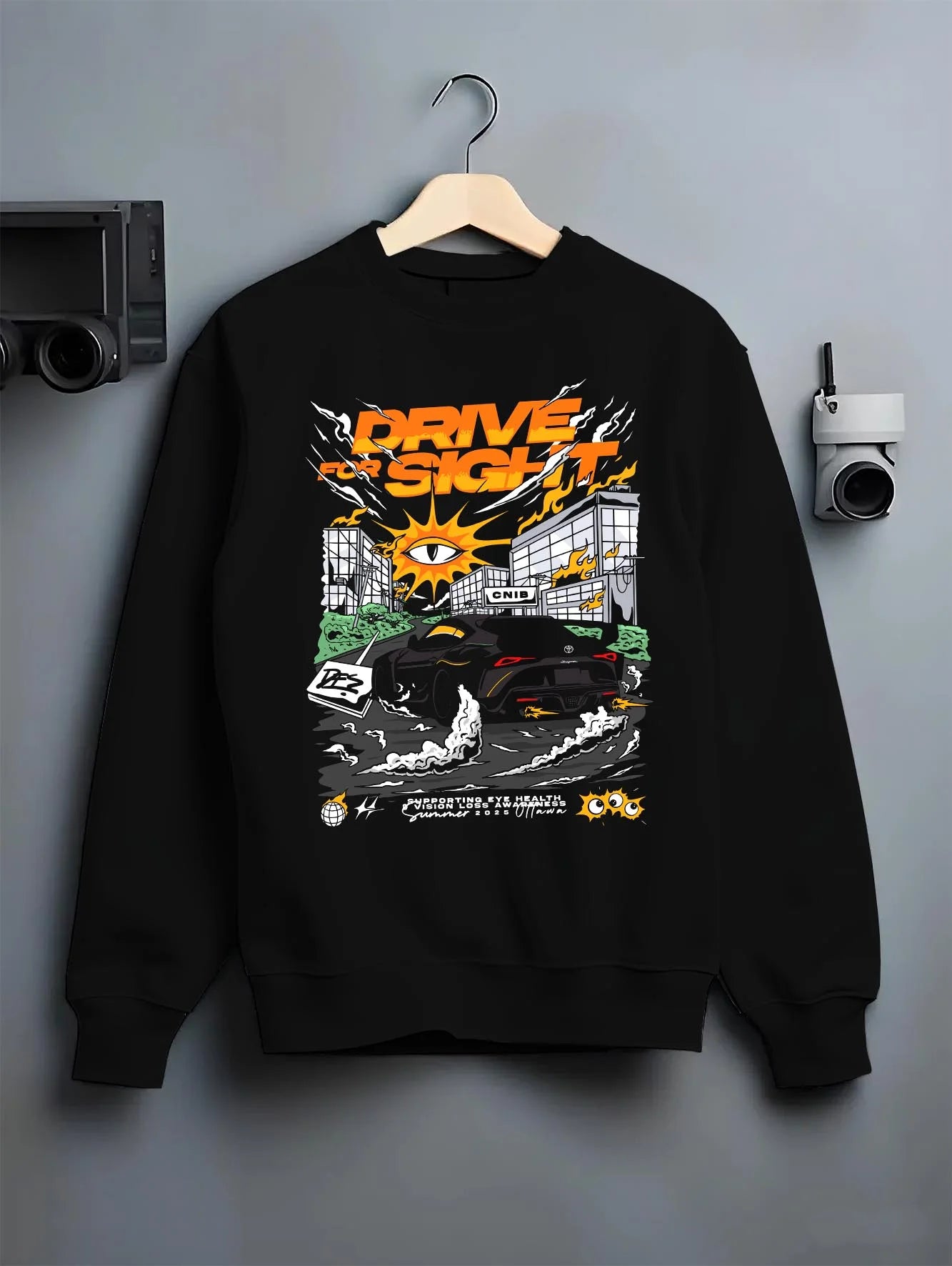 Black crewneck sweatshirt on a hanger against a grey wall, featuring racing drift street performance motorsport automotive graphic.