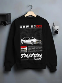 Black crewneck sweatshirt on a hanger against a grey wall, featuring BMW rs turbo racing drift motorsport euro street retro graphic.