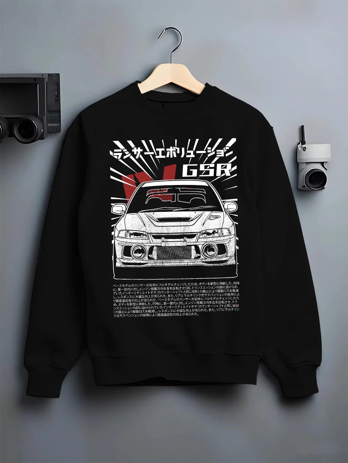 Black crewneck sweatshirt on a hanger against a grey wall, featuring Mitsubishi EVO lancer turbo racing drift jdm japanese graphic.