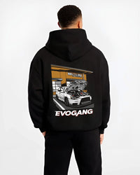 Black hoodie worn by a male model, back view, featuring Mitsubishi EVO rs racing jdm tuner street performance graphic.