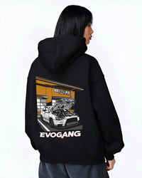 Black hoodie worn by a female model, back view, featuring Mitsubishi EVO rs racing jdm tuner street performance graphic.