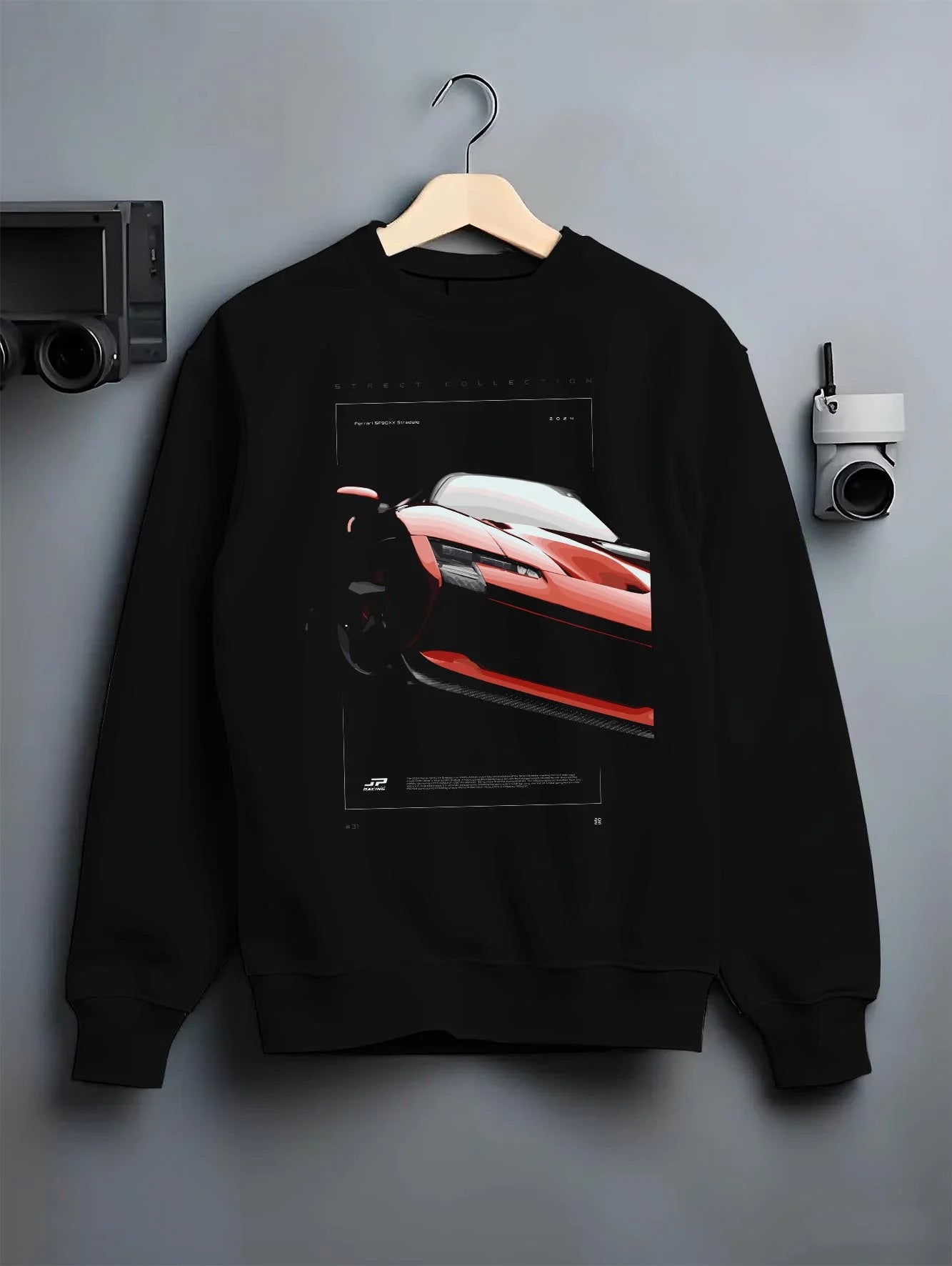Black crewneck sweatshirt on a hanger against a grey wall, featuring Ferrari SF90 racing street performance motorsport graphic.