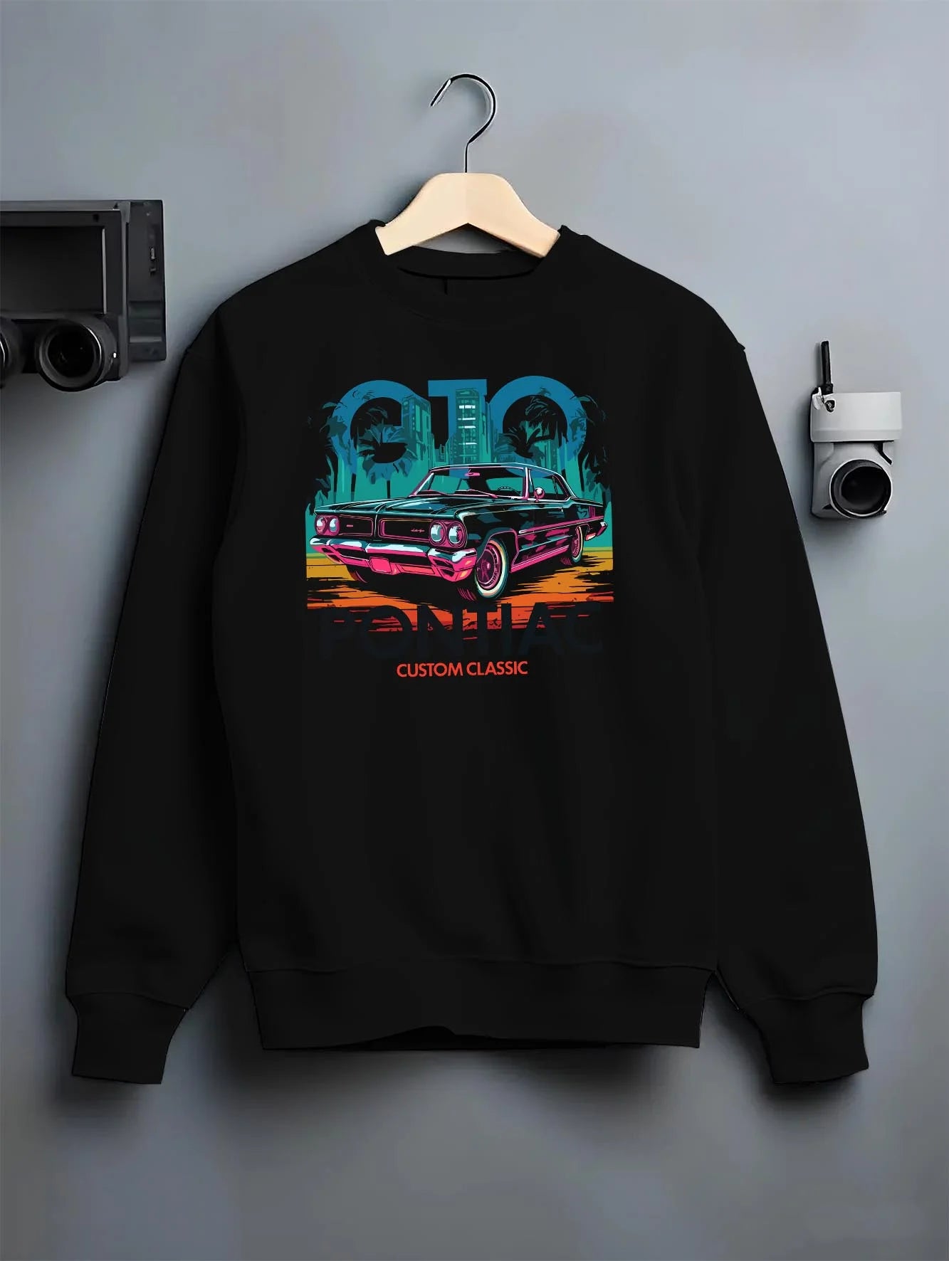 Black crewneck sweatshirt on a hanger against a grey wall, featuring Pontiac GTO muscle street retro vintage classic gto65.