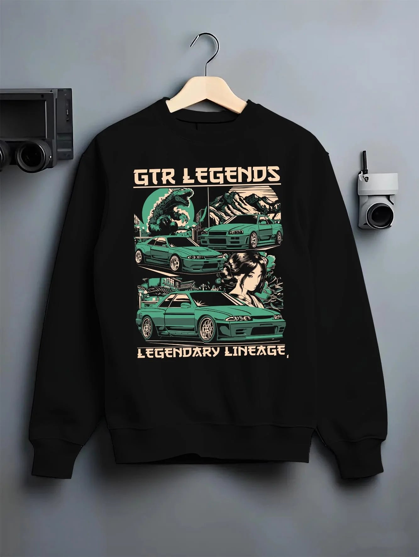 Black crewneck sweatshirt on a hanger against a grey wall, featuring SKYLINE gtr r32 r34 drift jdm street retro legend graphic.