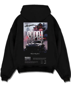 Black pullover hoodie laid flat on a white background, featuring Toyota Supra racing jdm japanese enthusiast street graphic.