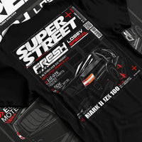 Black T-shirt laid flat with natural fabric folds, featuring Toyota JZX100 turbo drift street racing performance motorsport graphic.