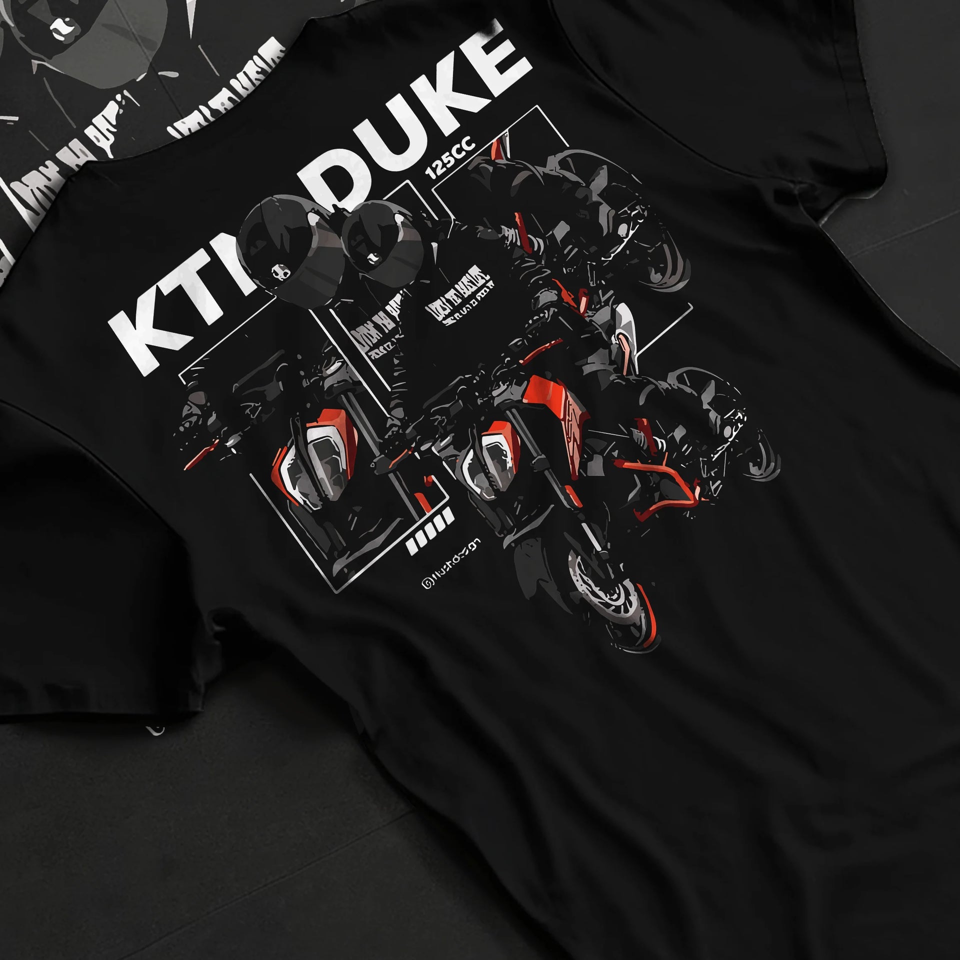 Black T-shirt laid flat with natural fabric folds, featuring KTM rs racing street performance motorsport automotive graphic.