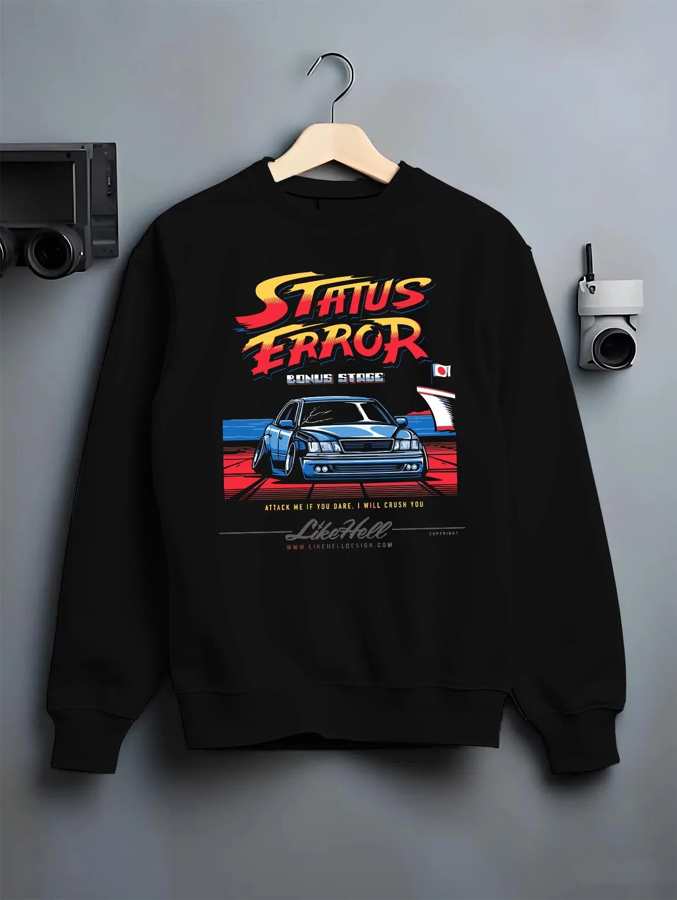 Black crewneck sweatshirt on a hanger against a grey wall, featuring Lexus racing drift tuner street enthusiast performance graphic.
