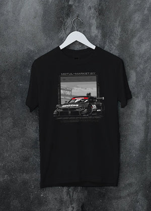 Black crewneck T-shirt on a hanger against a grey wall, featuring BMW M4 rs turbo racing motorsport german street graphic.