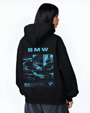 Black hoodie worn by a female model, back view, featuring BMW M5 rs turbo racing motorsport euro german street graphic.