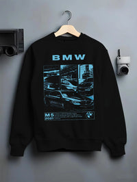 Black crewneck sweatshirt on a hanger against a grey wall, featuring BMW M5 rs turbo racing motorsport euro german street graphic.