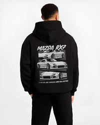 Black hoodie worn by a male model, back view, featuring Mazda RX--7 rx 7 racing drift jdm japanese street graphic.