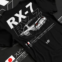 Black T-shirt laid flat with natural fabric folds, featuring Mazda RX--7 rx 7 racing drift jdm japanese street graphic mazr2.