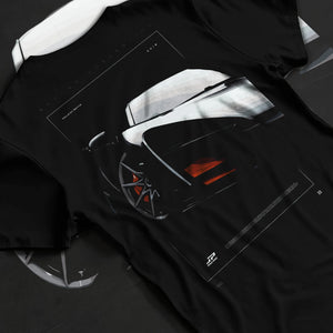 Black T-shirt laid flat with natural fabric folds, featuring McLaren F1 rs racing street retro speed enthusiast graphic.