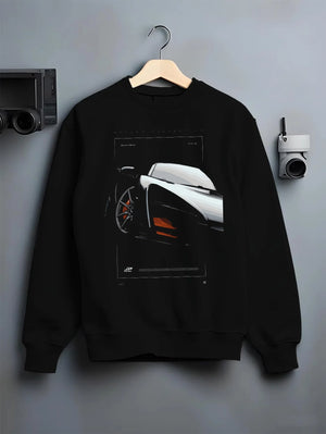Black crewneck sweatshirt on a hanger against a grey wall, featuring McLaren F1 rs racing street retro speed enthusiast graphic.
