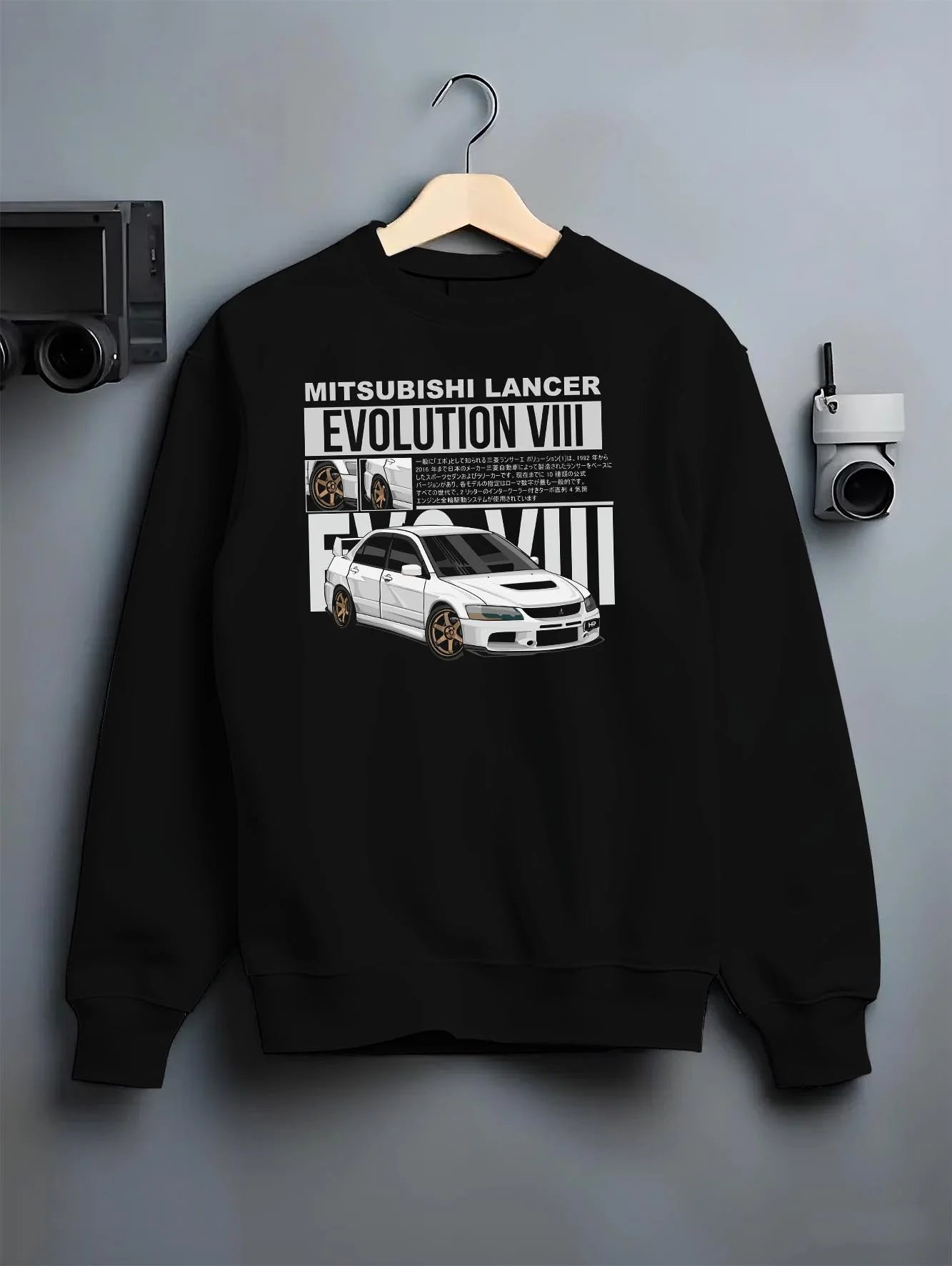 Black crewneck sweatshirt on a hanger against a grey wall, featuring street retro vintage racing performance motorsport graphic.