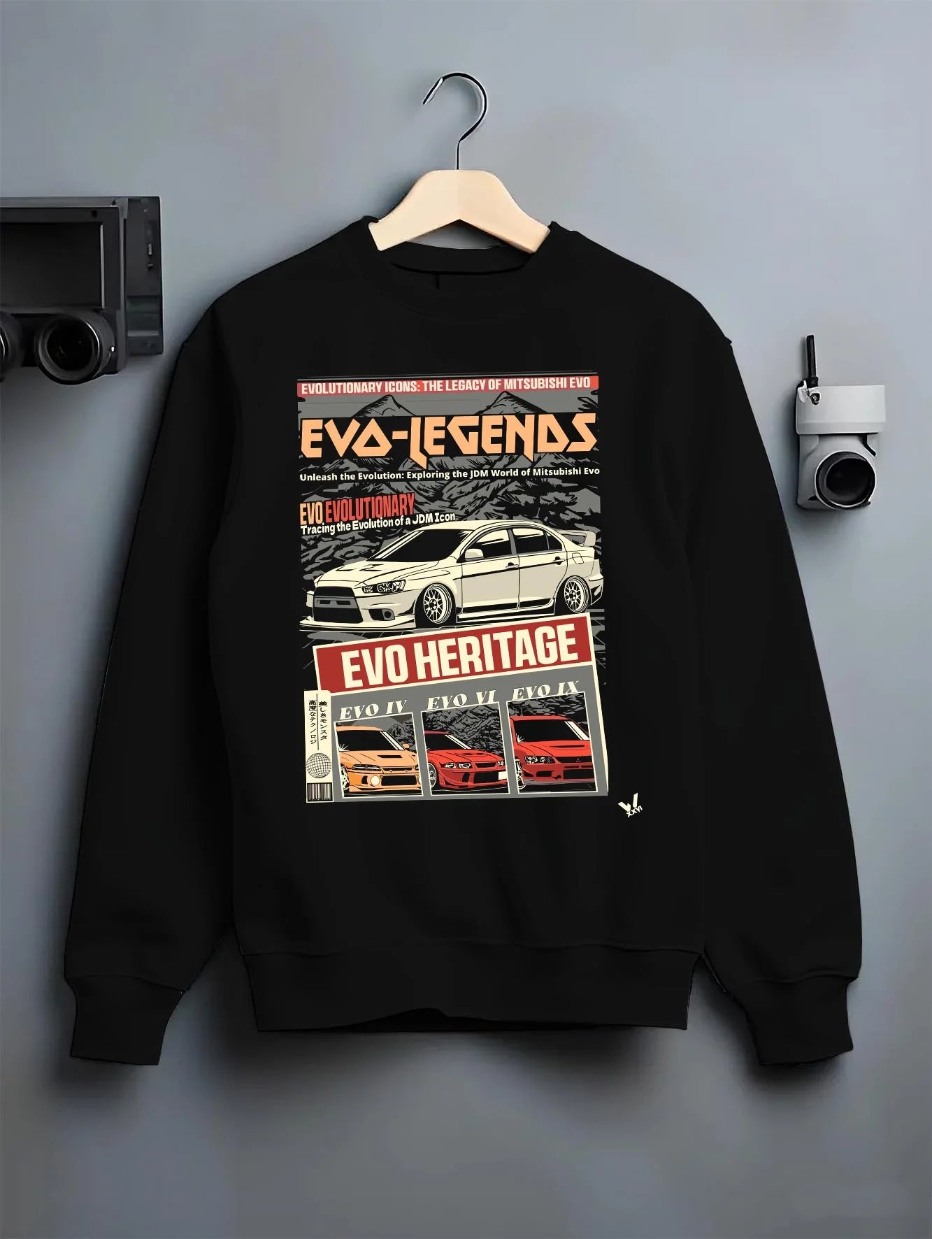 Black crewneck sweatshirt on a hanger against a grey wall, featuring Mitsubishi EVO turbo racing drift jdm japanese tuner graphic.
