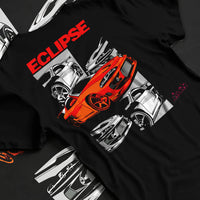 Black T-shirt laid flat with natural fabric folds, featuring Mitsubishi Lancer turbo racing drift track jdm street graphic.