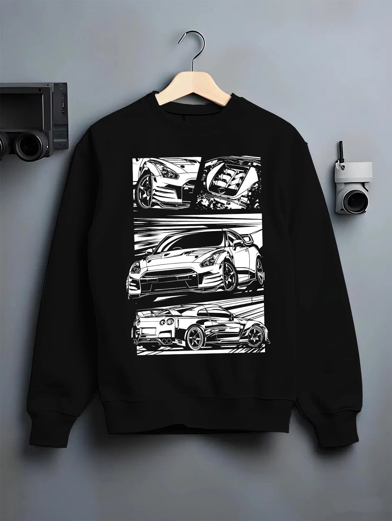 Black crewneck sweatshirt on a hanger against a grey wall, featuring Nissan GT-R gt r racing drift jdm japanese street graphic.