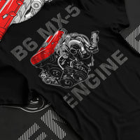 Black T-shirt laid flat with natural fabric folds, featuring Mazda MX-5 jdm tuner street racing performance motorsport graphic.