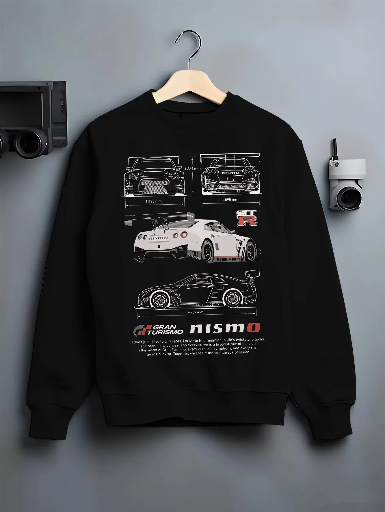 Black crewneck sweatshirt on a hanger against a grey wall, featuring Nissan GT-R gt r gran turismo legend racing street graphic.