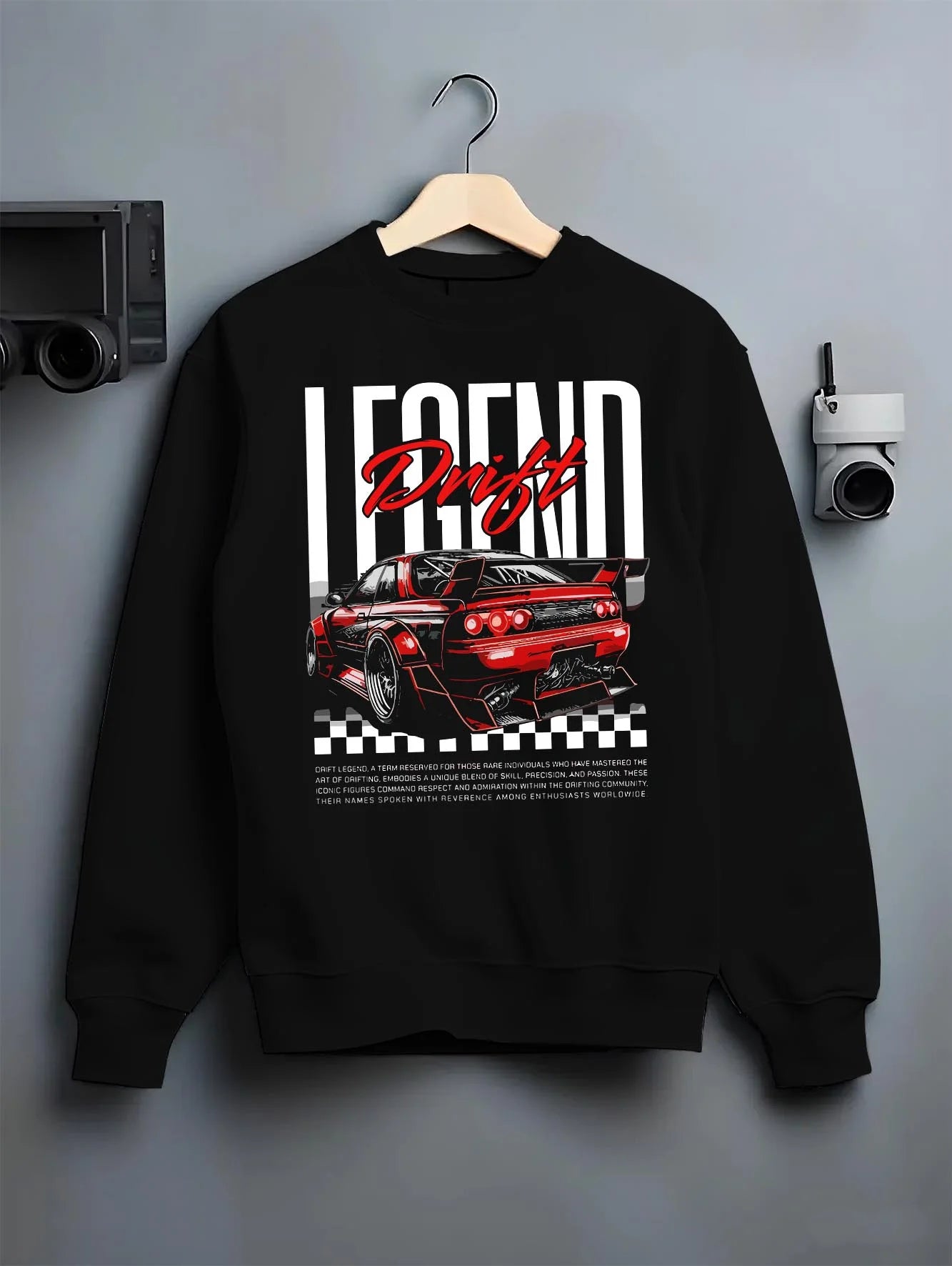 Black crewneck sweatshirt on a hanger against a grey wall, featuring Nissan GT-R R34 gtr r34 skyline racing drift jdm graphic.