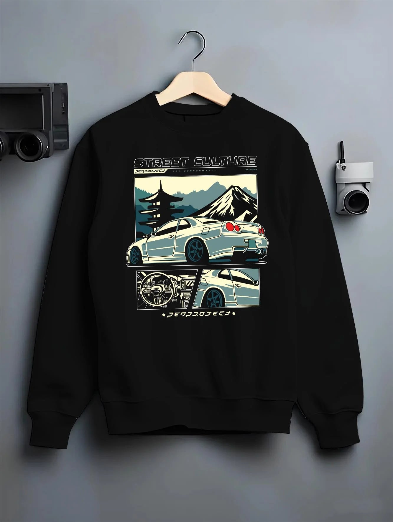 Black crewneck sweatshirt on a hanger against a grey wall, featuring Nissan Skyline drift jdm japanese tuner street retro graphic.