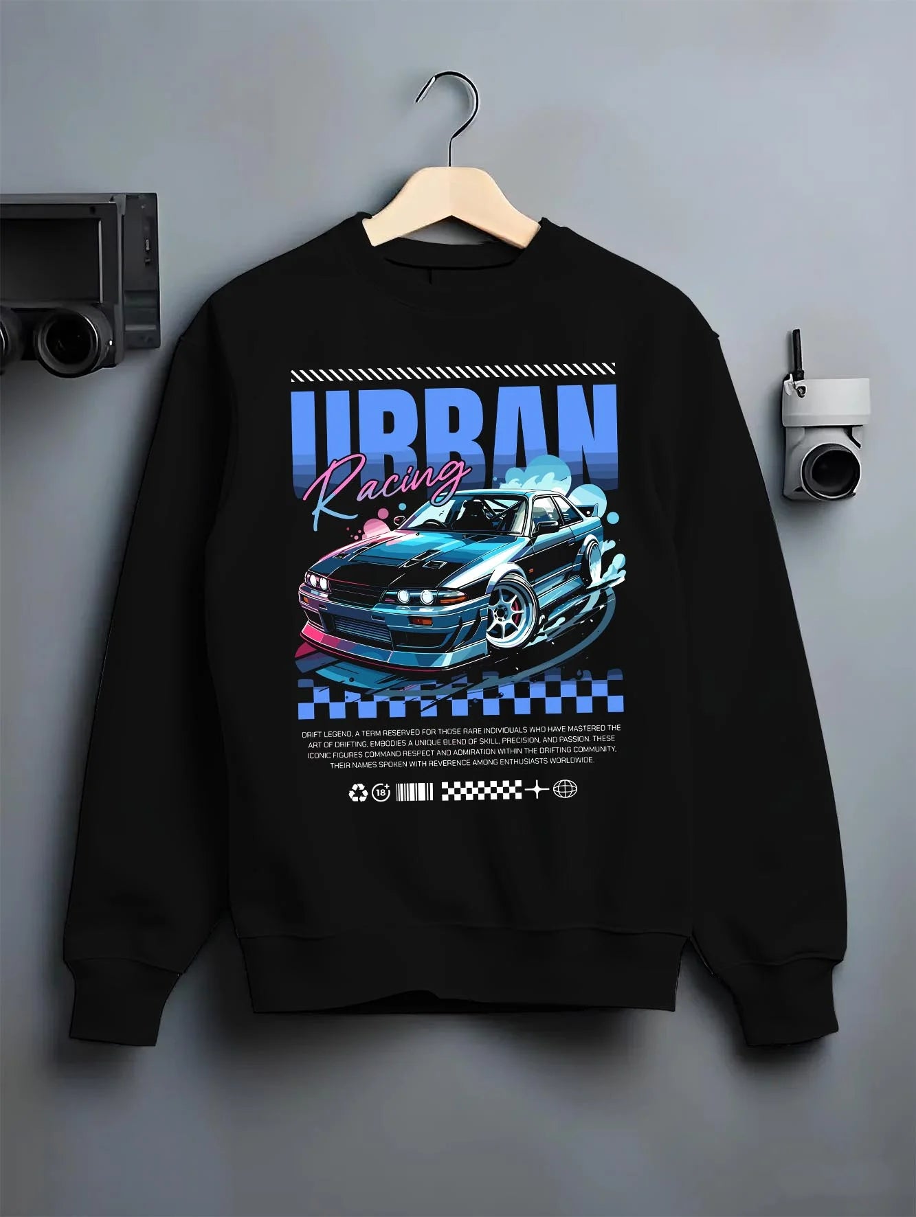 Black crewneck sweatshirt on a hanger against a grey wall, featuring Nissan Skyline racing drift jdm japanese street retro graphic.