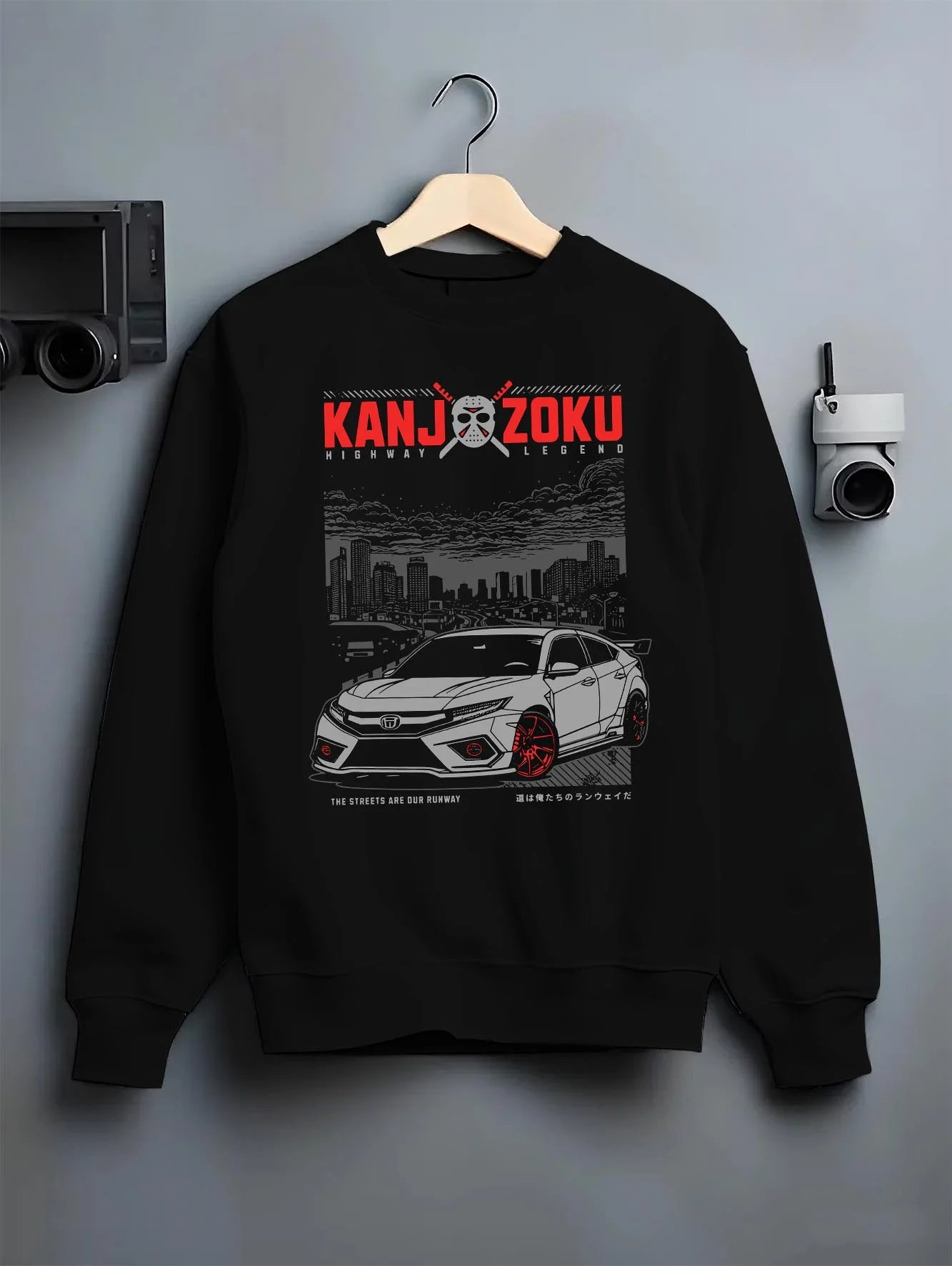 Black crewneck sweatshirt on a hanger against a grey wall, featuring Honda Nsx rs racing motorsport jdm street classic graphic.