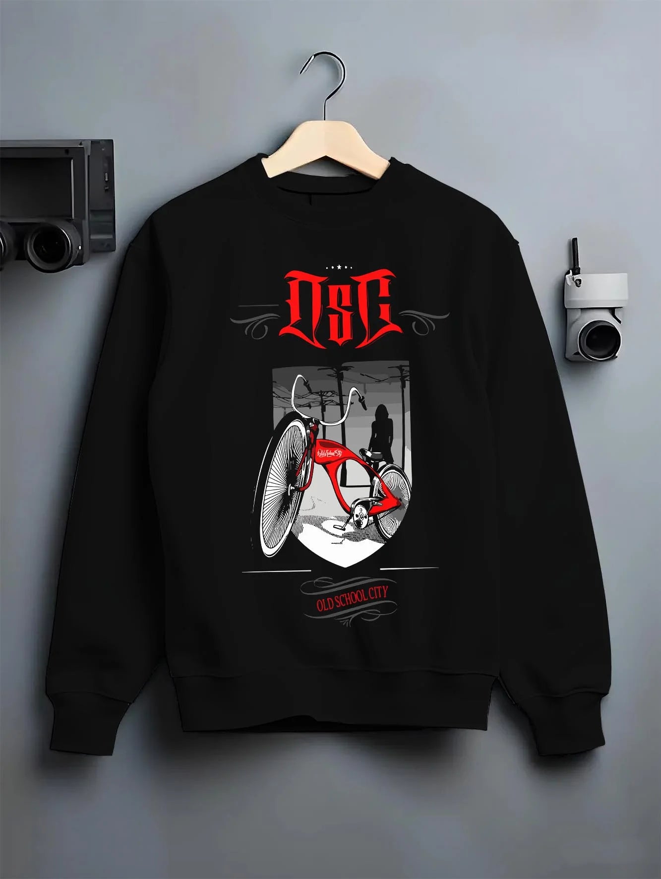 Black crewneck sweatshirt on a hanger against a grey wall, featuring street retro racing performance motorsport automotive osclwb.