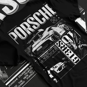 Black T-shirt laid flat with natural fabric folds, featuring Porsche Cayman rs turbo turbocharged racing german tuner graphic.