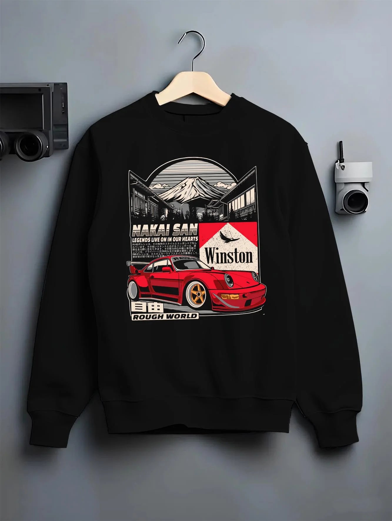 Black crewneck sweatshirt on a hanger against a grey wall, featuring Porsche rs racing jdm euro widebody rwb street graphic.